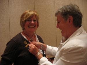 June Dale getting her new "Master Director 700" pin put on by Joan Borden--a new Master Director & Novice Director too!
